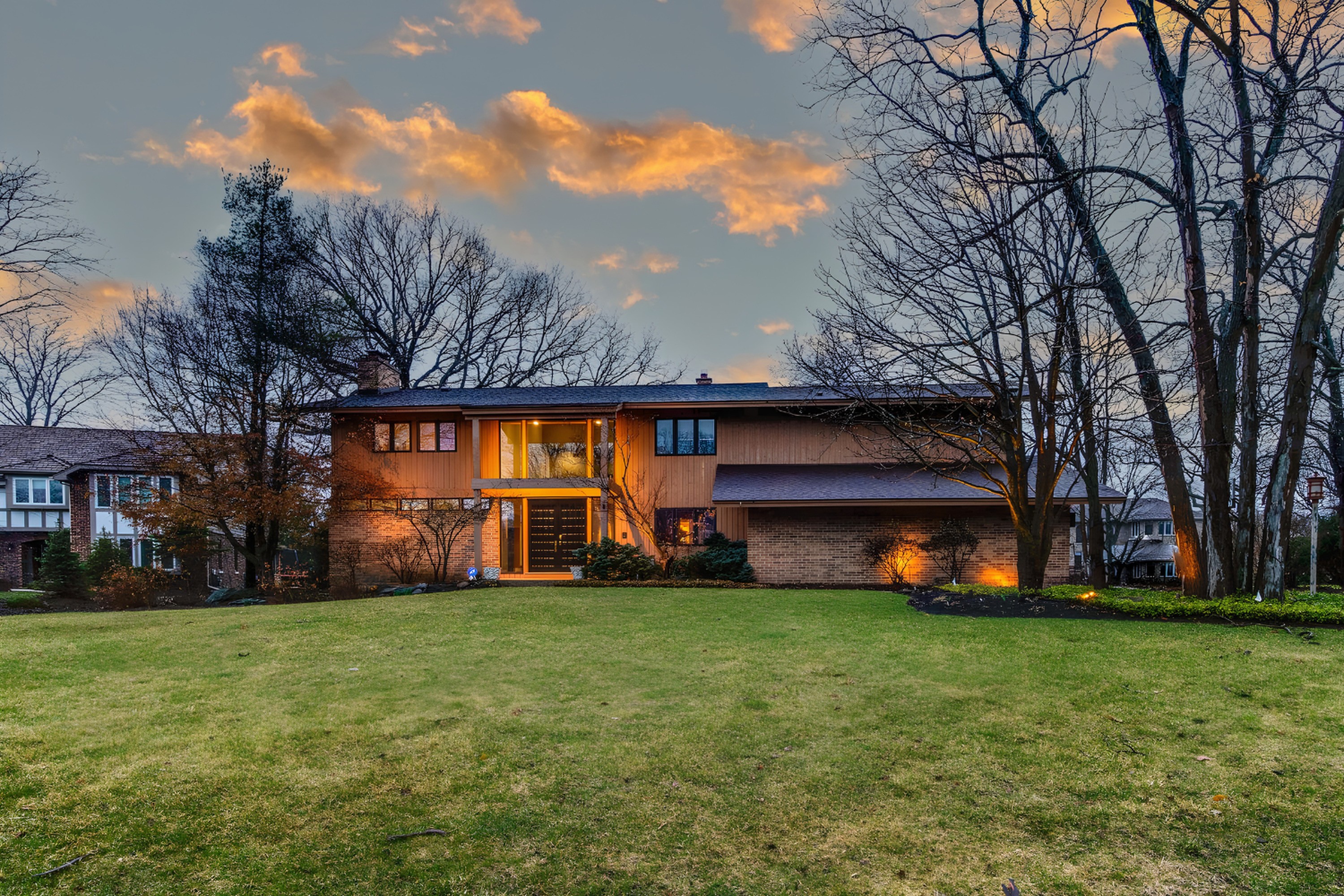 Mid-century home lit at dusk, a Gimbel Group listing